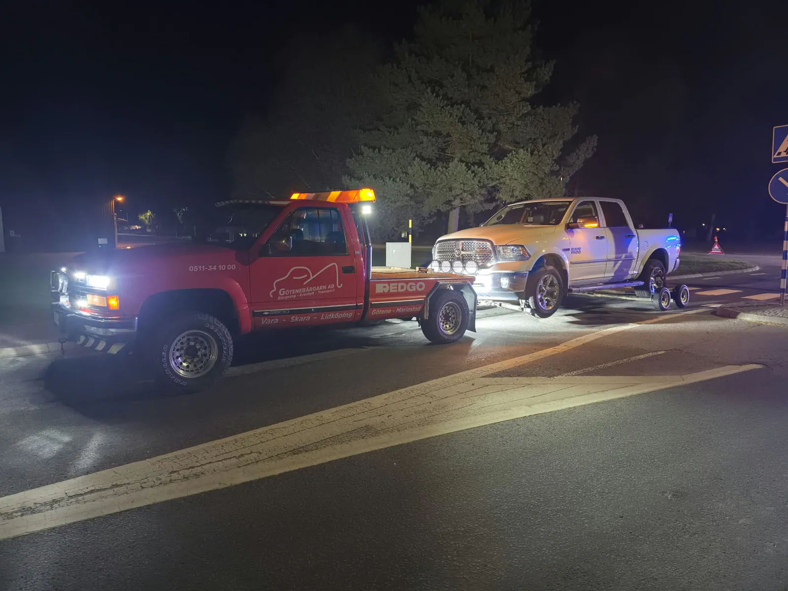 Den mindre Chevrolet-bärgaren transporterar en stor RAM-pickup