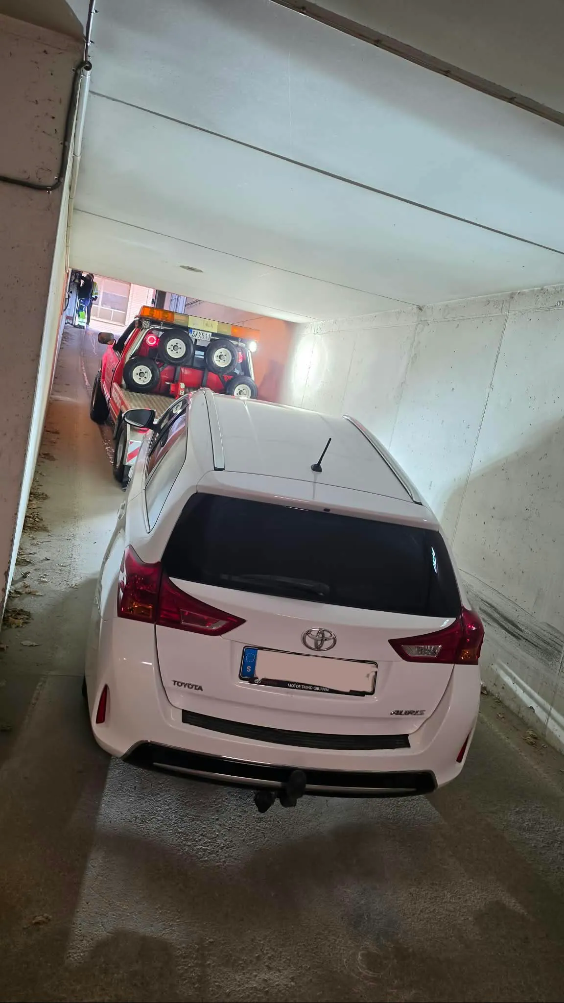 Den mindre Chevrolet-bärgaren hjälper en bil i ett trångt garage