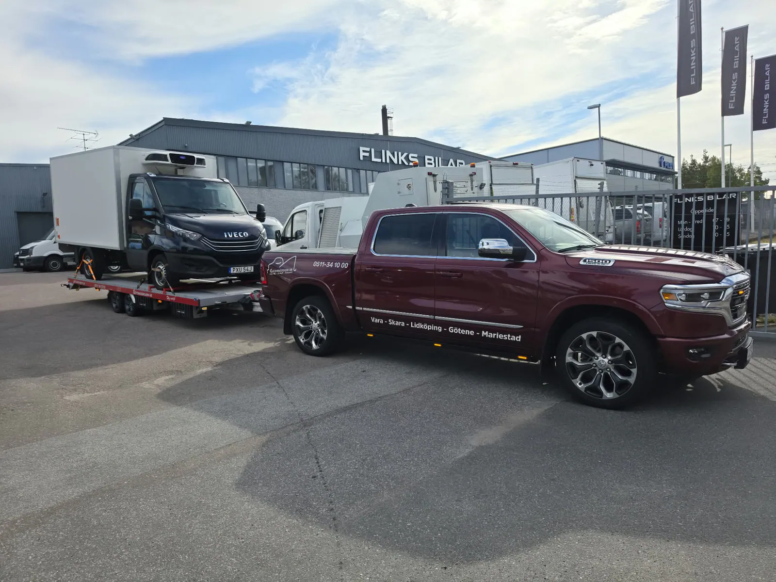 Röd RAM 1500 transporterar en skåpbil på biltransport